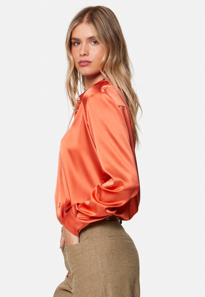 Woman wearing orange silk satin shirt