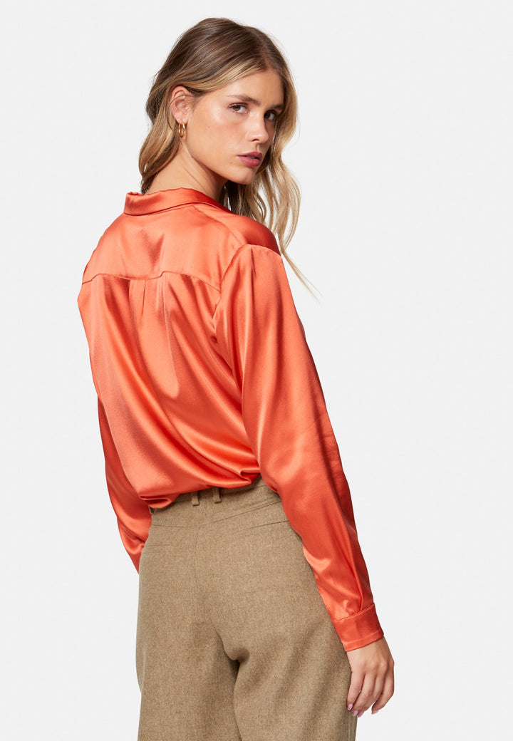 Woman wearing orange silk satin shirt
