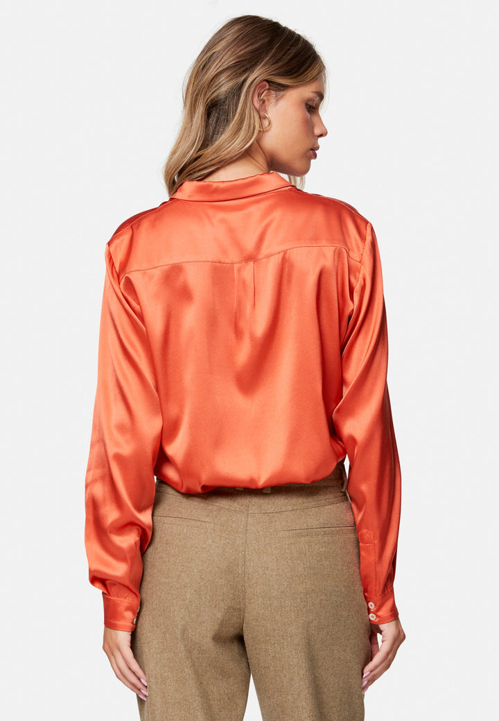 Woman wearing orange silk satin shirt