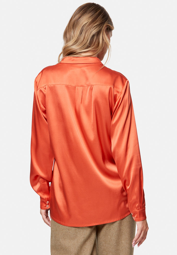 Woman wearing orange silk satin shirt