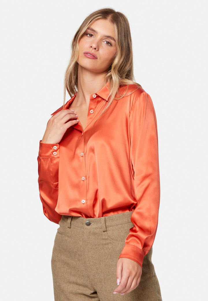 Woman wearing orange silk satin shirt