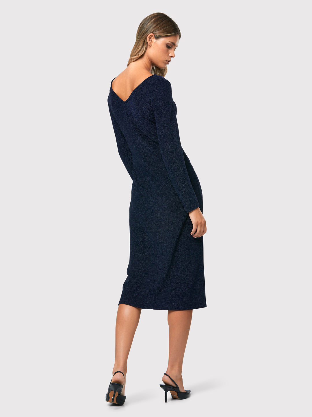 Introducing the Jamie Midnight Shimmer Dress, a captivating bodycon dress that exudes timeless elegance. This dress features super full-length sleeves, providing a sophisticated and chic look. Crafted from a sparkly navy jersey fabric, it adds a touch of glamour to your ensemble. The slash neck with a slight V-back detail adds a subtle hint of allure. 