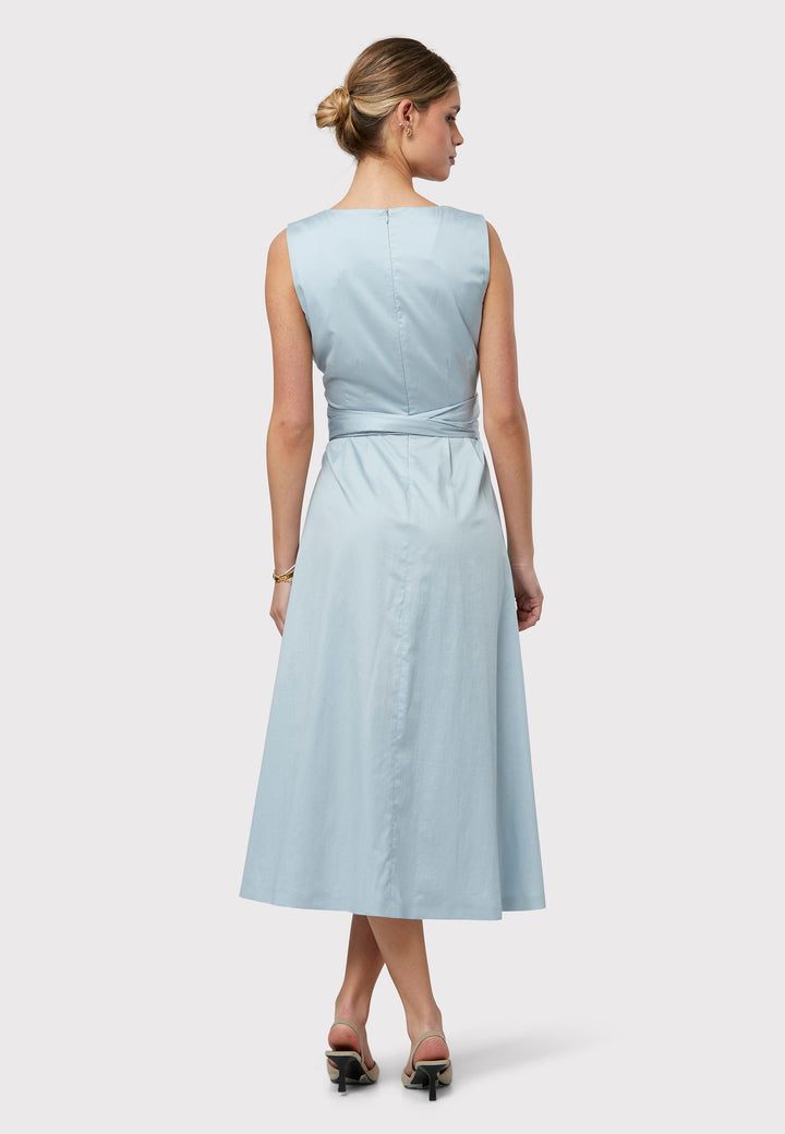 Introducing Avril, a sleeveless dress crafted in luxurious cotton poplin, showcasing a tie waist and charming keyhole back detail. Designed with a flattering empire line silhouette that gracefully skims the body, culminating in a chic mid-calf hemline. Now available in a captivating dusty blue shade, destined to be a standout piece in your wardrobe collection.