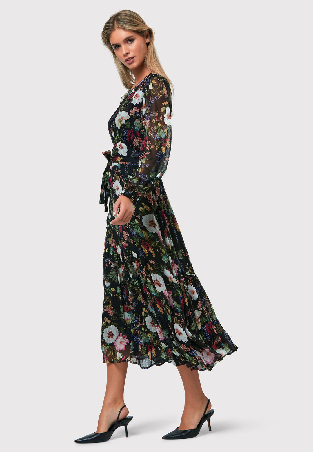 Bev Floral Noir Print Dress, a sophisticated choice that adds an elegant touch to your everyday wardrobe, now and in the future. This exquisite dress features a sweeping midi-length silhouette, designed with a blend of simplicity and feminine flair. The Jewel neckline is delicately enhanced with gentle gathers, while the softly flared skirt offers a flattering fit. 
