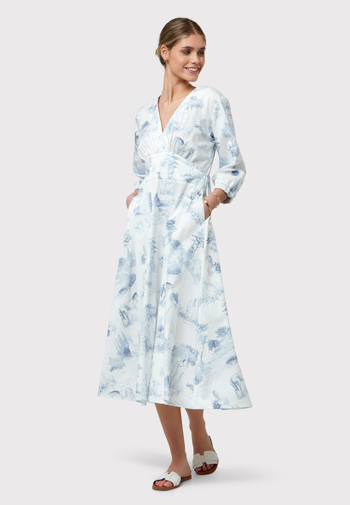 Inject some feminine style into your summer wardrobe with Bonnie. Cut from crisp cotton in a blue and white toile de Jouy print, this piece brings a timeless charm to your collection. The defined waist beautifully shapes the frame, while the V-neckline adds a touch of allure to the classic flared silhouett