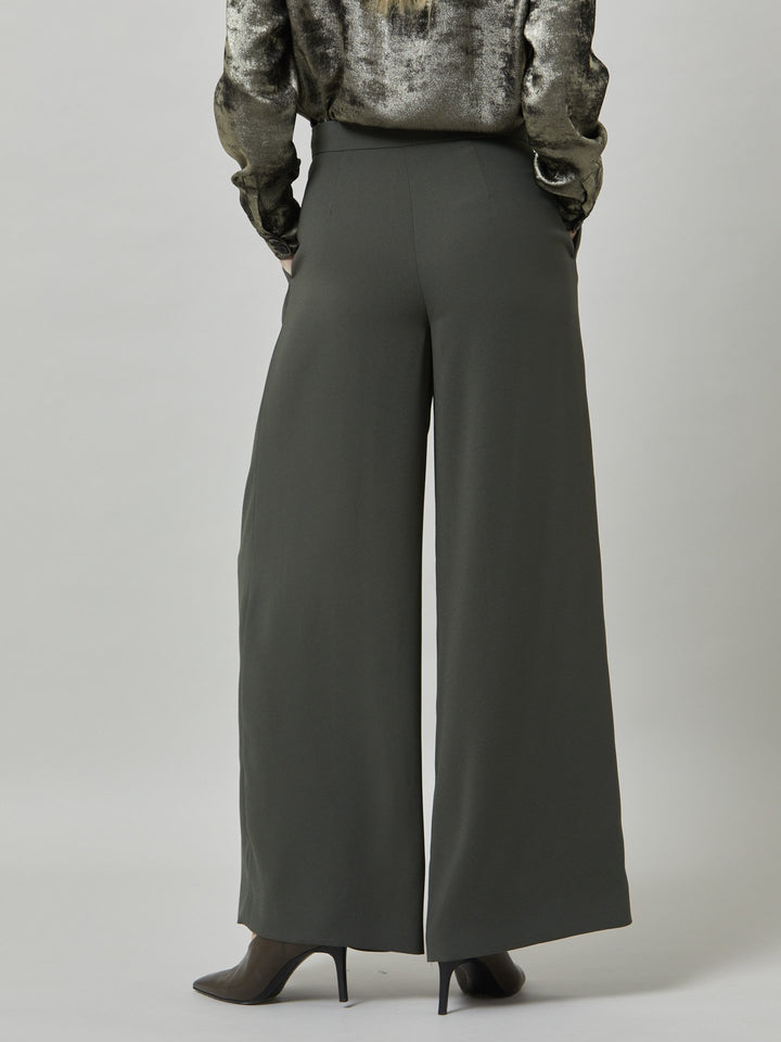 Charlize, a wide-leg palazzo pant. crafted in a satin back crepe in rich olive features deep pleats, sharp front crease & side pockets. A high-waisted trouser made to take you from desk to dinner with a relaxed & refined silhouette. Style with flats or dress up with heels.