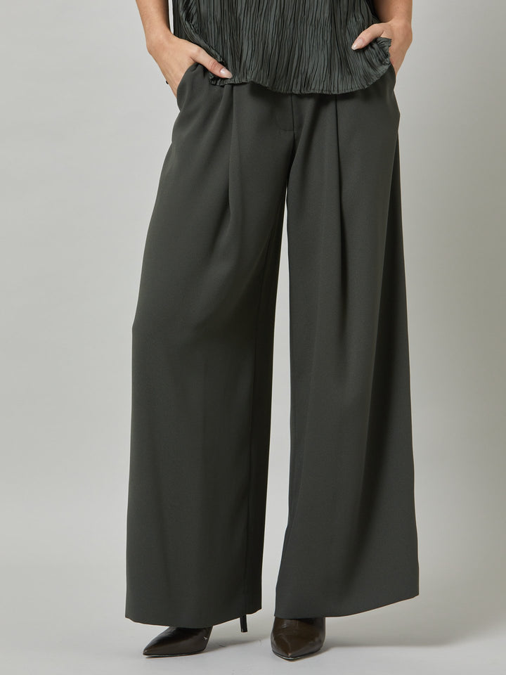 Charlize, a wide-leg palazzo pant. crafted in a satin back crepe in rich olive features deep pleats, sharp front crease & side pockets. A high-waisted trouser made to take you from desk to dinner with a relaxed & refined silhouette. Style with flats or dress up with heels.