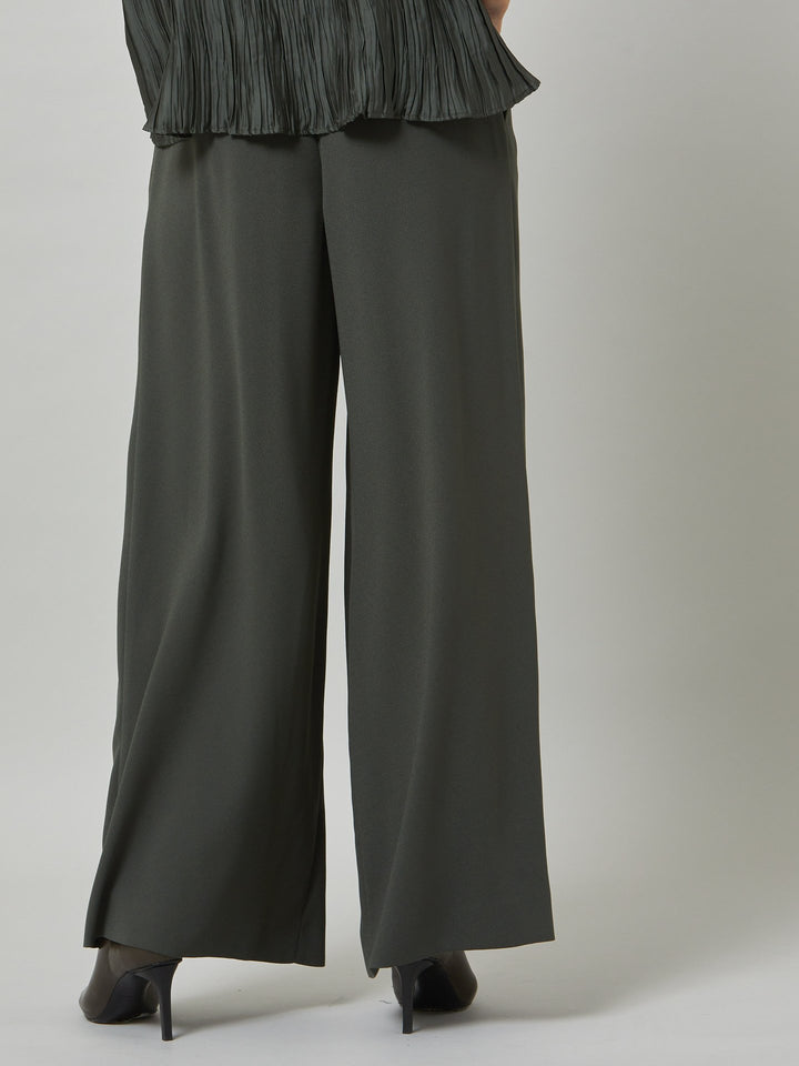 Charlize, a wide-leg palazzo pant. crafted in a satin back crepe in rich olive features deep pleats, sharp front crease & side pockets. A high-waisted trouser made to take you from desk to dinner with a relaxed & refined silhouette. Style with flats or dress up with heels.