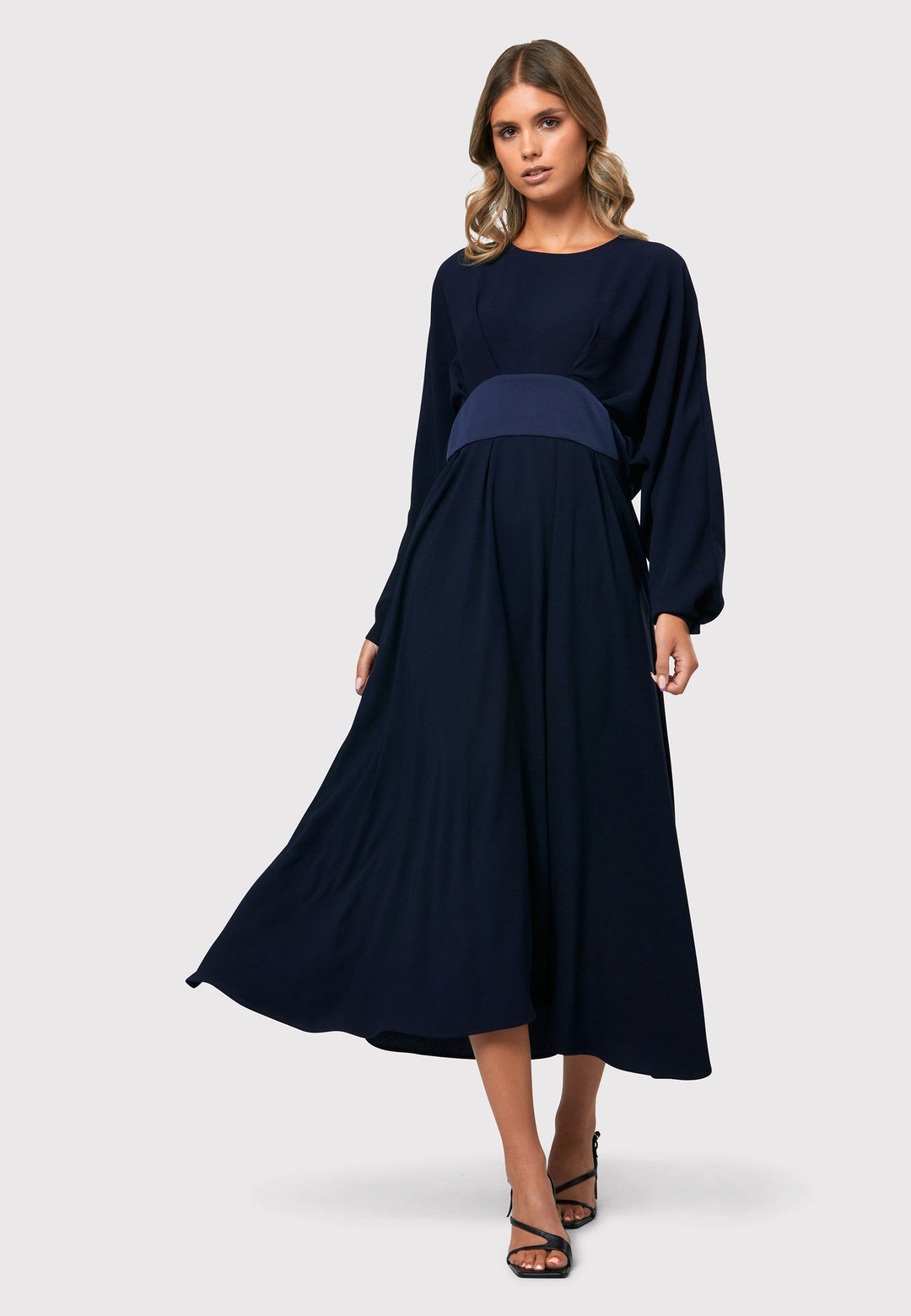 Drew Midnight Navy Dress, an ankle-grazing ensemble crafted from luxurious satin back crepe. This dress exudes elegance with its sophisticated design. The satin empire line panel beautifully accentuates the waist, creating a flattering silhouette. The dress features dropped sleeves, adding a touch of modernity to the overall look. 