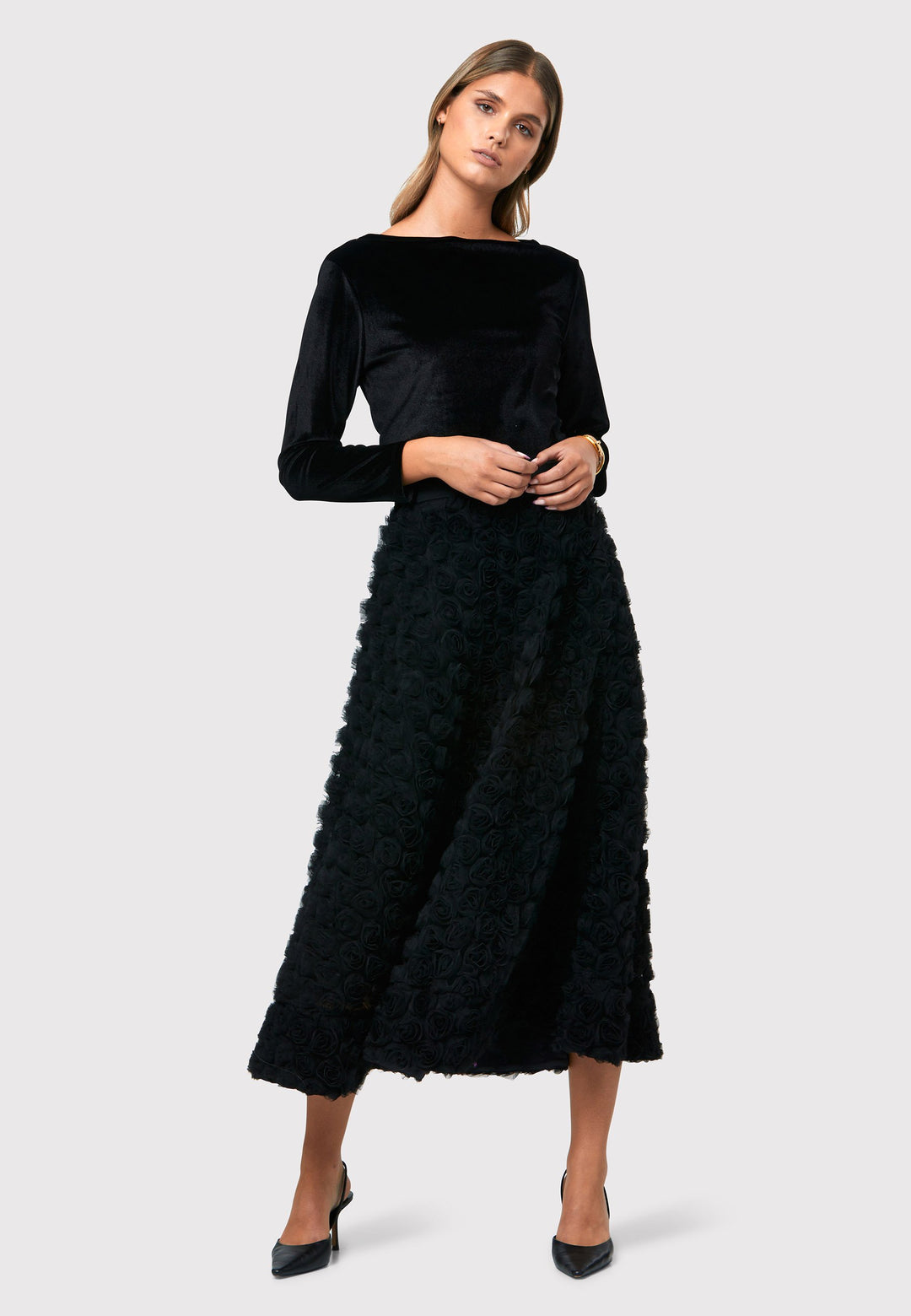 Introducing the Felicity Black Rose Skirt, a chic mid-calf length skirt inspired by 1950s fashion. Made from textured rose georgette fabric. An A-line silhouette reminiscent of the iconic 50s style. This statement piece features a convenient side seam zip, ensuring easy and comfortable wearing. Perfect for special occasions, it adds an elegant touch to your ensemble, making you the center of attention with its captivating beauty.
