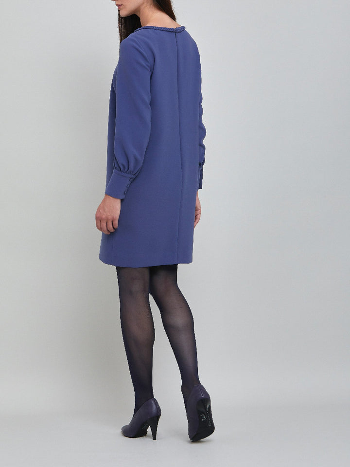 Rachel, a contemporary form-flattering shift dress. Crafted in a juniper blue tricotine with a hint of stretch. The round neck features an elegant plait trim & the easy-fitting sleeve softly gathers into a buttoned cuff. The skirt skims the knee. Work, Wine, or Dine in the Rachel Dress.