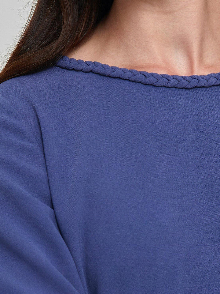 Rachel, a contemporary form-flattering shift dress. Crafted in a juniper blue tricotine with a hint of stretch. The round neck features an elegant plait trim & the easy-fitting sleeve softly gathers into a buttoned cuff. The skirt skims the knee. Work, Wine, or Dine in the Rachel Dress.