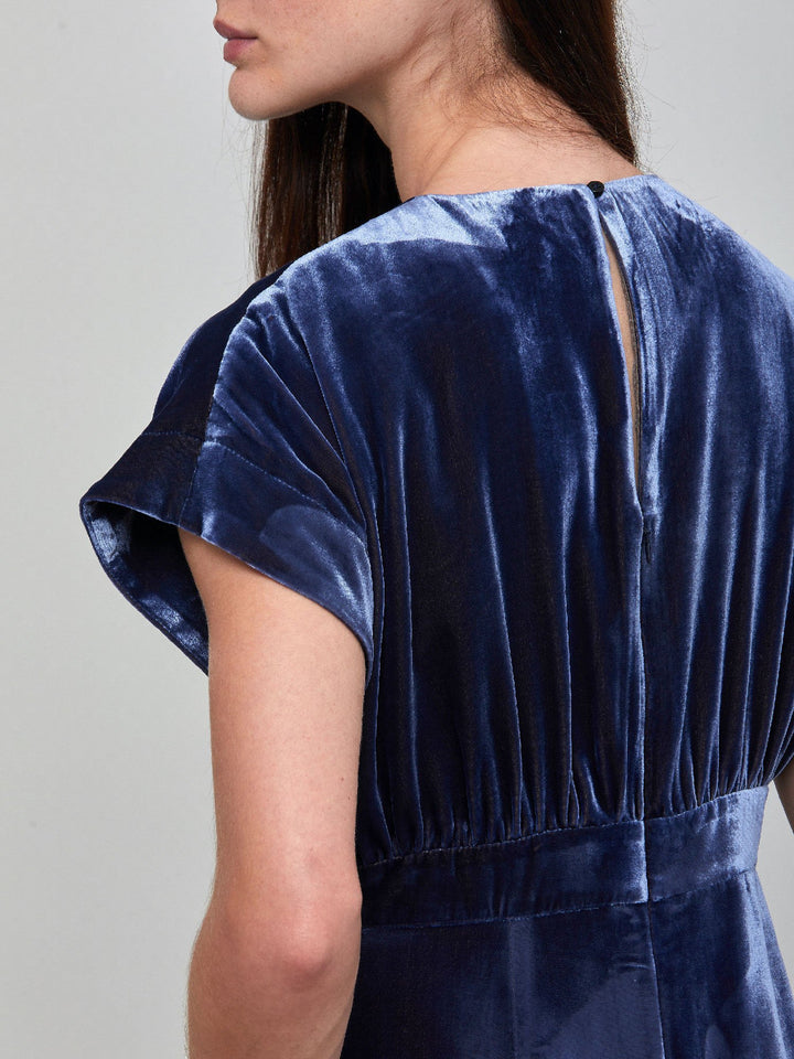 Occasionwear modernized. Meet the Shiv Juniper blue dress in Luxurious fluid velvet. An easy-fitting silhouette with side seam pockets falls to the mid-calf & features a side slit, dropped sleeves, and an elegant key-hole back neck detail. Attending a winter wedding? This is the dress for you.