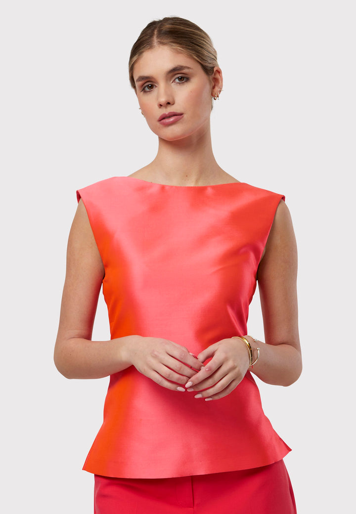 Stella Begonia Orange Top, a sleeveless foundation designed to complement our coordinating suiting or stand beautifully on its own. Boasting an iridescent sheen, this piece features two side slits and a central back zip. Embrace the vibrancy of spring with its captivating hue and playful elegance.