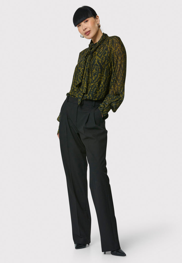 Anastasia Dark Green Forest Print Blouse, crafted from a luxurious viscose and silk blend, is perfect for your workwear wardrobe. This blouse features a round neckline, a chic pussy bow tie, and comes with a detachable slip. Pair it with the Marlena Sleeveless Chartreuse Green cashmere top, styled as a sweater vest, for a polished and professional look.