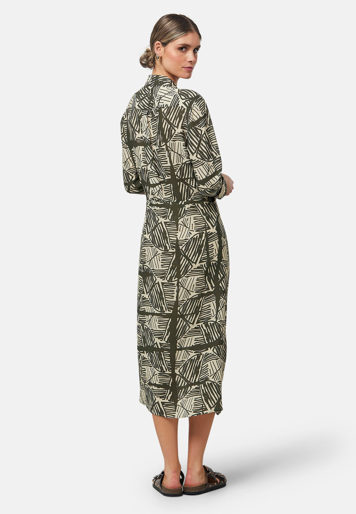 This Ashley Ogham Print Shirt Dress is a modern take on the classic shirt dress. Featuring a button-down front with a placket, full length sleeves with a button cuffed finish and simple shirt collar, it offers versatility and style. The wrap skirt ties off center to the front of the dress.