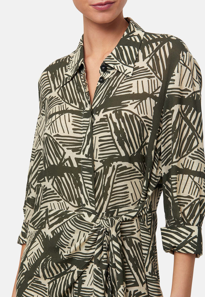 This Ashley Ogham Print Shirt Dress is a modern take on the classic shirt dress. Featuring a button-down front with a placket, full length sleeves with a button cuffed finish and simple shirt collar, it offers versatility and style. The wrap skirt ties off center to the front of the dress.