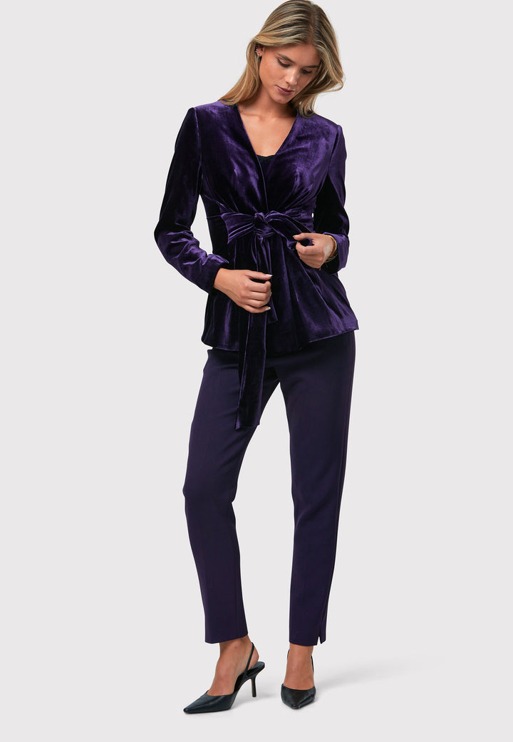 The Aurora Twilight Plum Velvet Jacket is an elegant addition to your evening wardrobe. Designed with a wrap front and a self-tie attached belt, allowing for a customizable fit. Pair with the matching Naomi trousers for a full glam look, or style it with the coordinating Jill trousers for a chic and simple style.