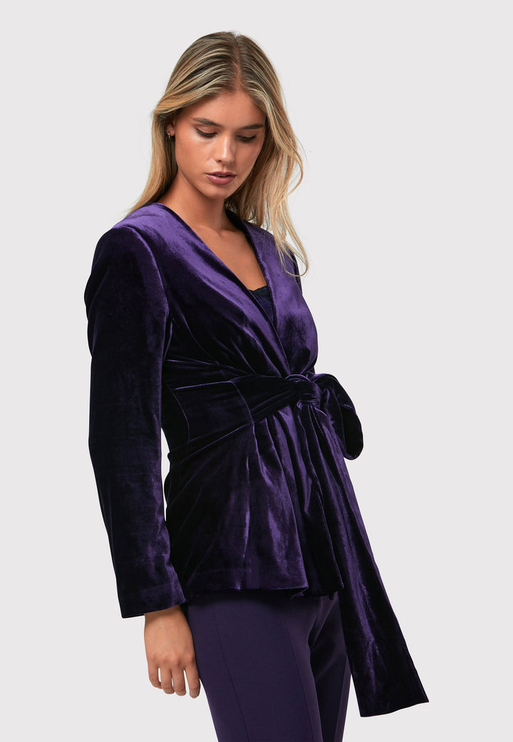 The Aurora Twilight Plum Velvet Jacket is an elegant addition to your evening wardrobe. Designed with a wrap front and a self-tie attached belt, allowing for a customizable fit. Pair with the matching Naomi trousers for a full glam look, or style it with the coordinating Jill trousers for a chic and simple style.