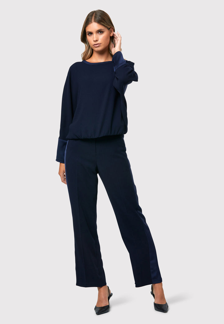 Delilah Midnight Navy Trousers, a classic wardrobe staple that combines comfort and relaxed elegance. These flat front pants are designed to sit at the natural waist and gracefully fall into a relaxed straight leg silhouette. With side pockets and an elasticated back waist, they ensure both style and comfort.