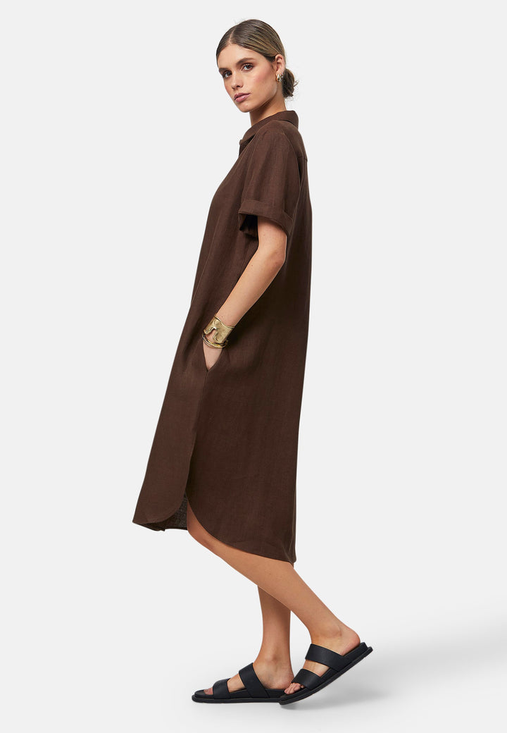 Bella, a relaxed brown shirt dress, offers effortless style with its button-down front, short T-shirt length sleeves, and curved hem. Crafted from breathable Baird McNuit Irish linen fabric, it’s perfect for warm-weather days. It combines comfort and versatility, making it a great choice for casual outings or laid-back weekends.