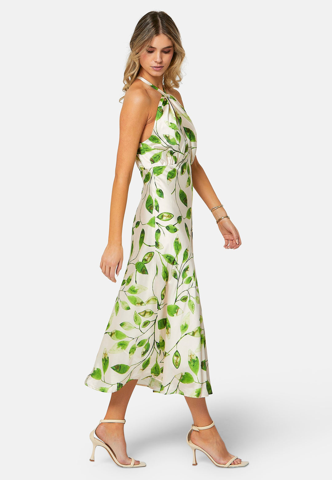 Introducing the Bronagh Leafy Print Dress: Elevate your summer wardrobe with this ankle-length halter neck dress, exquisitely designed for those special occasions. The dress features a bias-cut skirt that gracefully flows with every step, enhancing its feminine allure. The adjustable neck tie allows for a customizable fit, while the intricate knotted and twisted detail at the neckline adds an elegant touch to the halter design. 