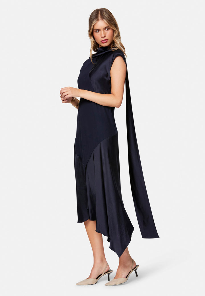 Carmin, the modern occasion dress with quiet drama. Cut from fluid, silk-touch satin in deep navy, it skims rather than clings, with a jewel neckline. Bias-cut panels and an asymmetric handkerchief hem add interest, while cap sleeves offer extra coverage. Style it with barely-there heels for evening, or a sharp blazer for city events.