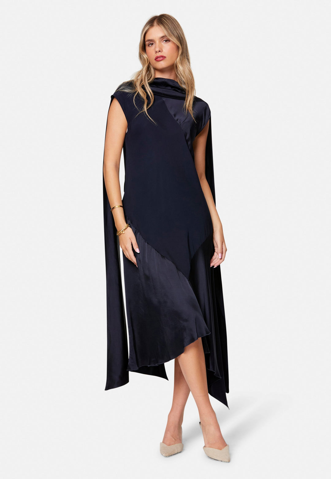 Carmin, the modern occasion dress with quiet drama. Cut from fluid, silk-touch satin in deep navy, it skims rather than clings, with a jewel neckline. Bias-cut panels and an asymmetric handkerchief hem add interest, while cap sleeves offer extra coverage. Style it with barely-there heels for evening, or a sharp blazer for city events.