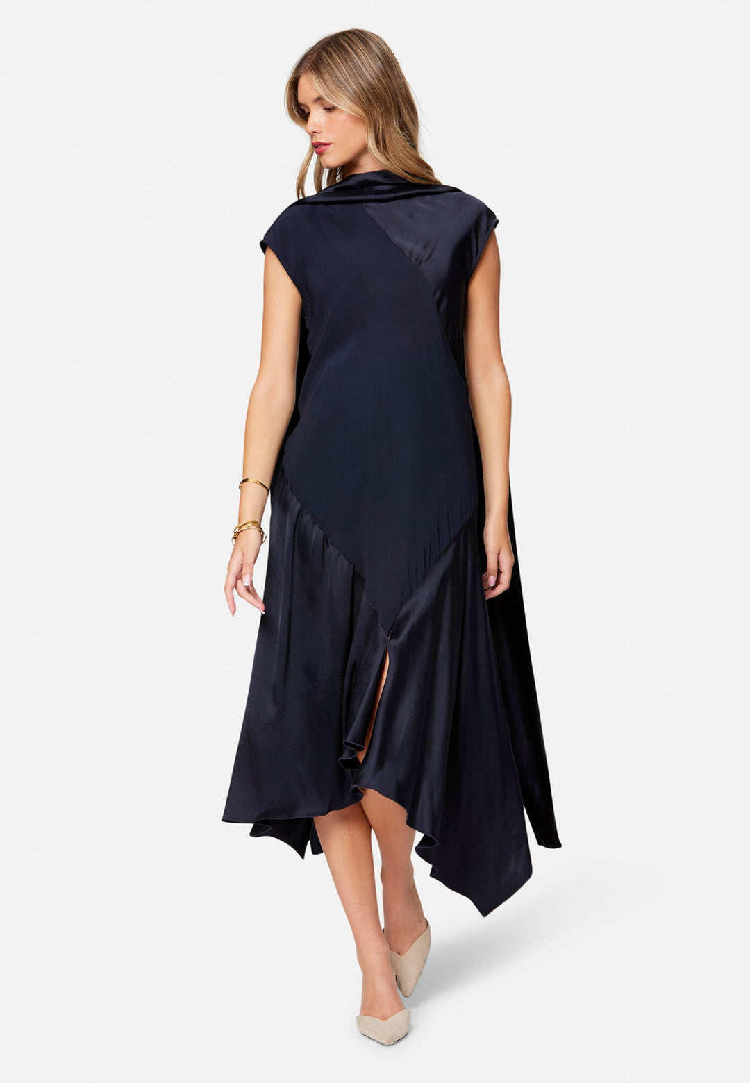 Carmin, the modern occasion dress with quiet drama. Cut from fluid, silk-touch satin in deep navy, it skims rather than clings, with a jewel neckline. Bias-cut panels and an asymmetric handkerchief hem add interest, while cap sleeves offer extra coverage. Style it with barely-there heels for evening, or a sharp blazer for city events.