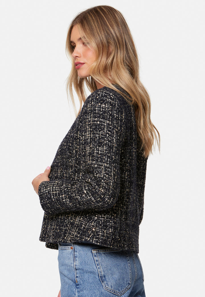 Cassandra, the navy bouclé jacket that pulls everything together. Cut to a neat, waist-defining silhouette with a clean round neckline and long sleeves, it’s woven in textured navy bouclé flecked with light neutrals and burnished metallic threads. Statement gold-rim buttons add polish, while the hip-skimming length makes it effortless over dresses, denim or tailoring. Style with the Lyra or Georgina trousers for a modern suit, or throw on with a tee for off-duty chic.