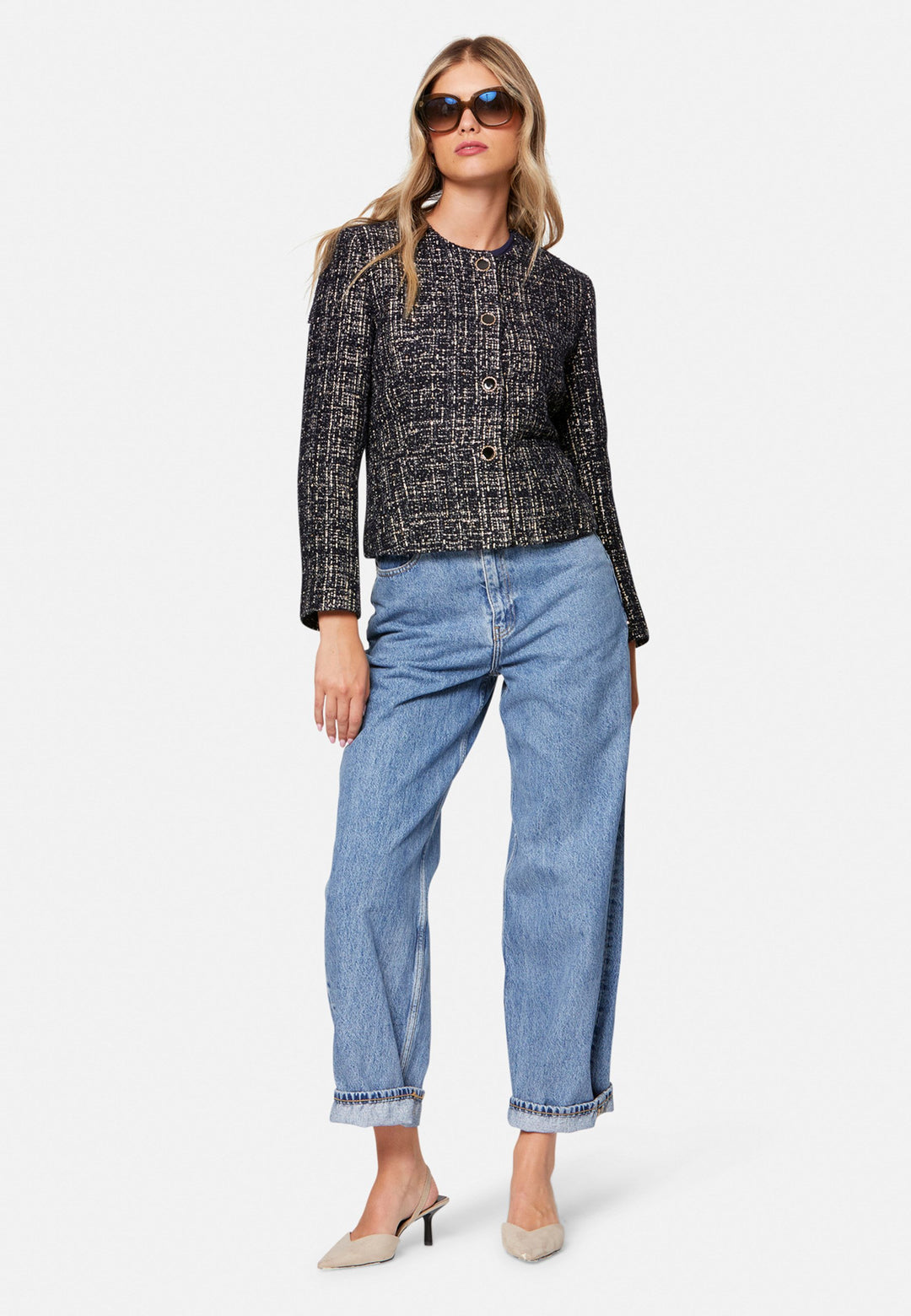 Cassandra, the navy bouclé jacket that pulls everything together. Cut to a neat, waist-defining silhouette with a clean round neckline and long sleeves, it’s woven in textured navy bouclé flecked with light neutrals and burnished metallic threads. Statement gold-rim buttons add polish, while the hip-skimming length makes it effortless over dresses, denim or tailoring. Style with the Lyra or Georgina trousers for a modern suit, or throw on with a tee for off-duty chic.