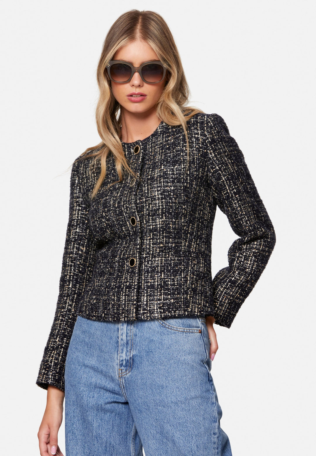 Cassandra, the navy bouclé jacket that pulls everything together. Cut to a neat, waist-defining silhouette with a clean round neckline and long sleeves, it’s woven in textured navy bouclé flecked with light neutrals and burnished metallic threads. Statement gold-rim buttons add polish, while the hip-skimming length makes it effortless over dresses, denim or tailoring. Style with the Lyra or Georgina trousers for a modern suit, or throw on with a tee for off-duty chic.