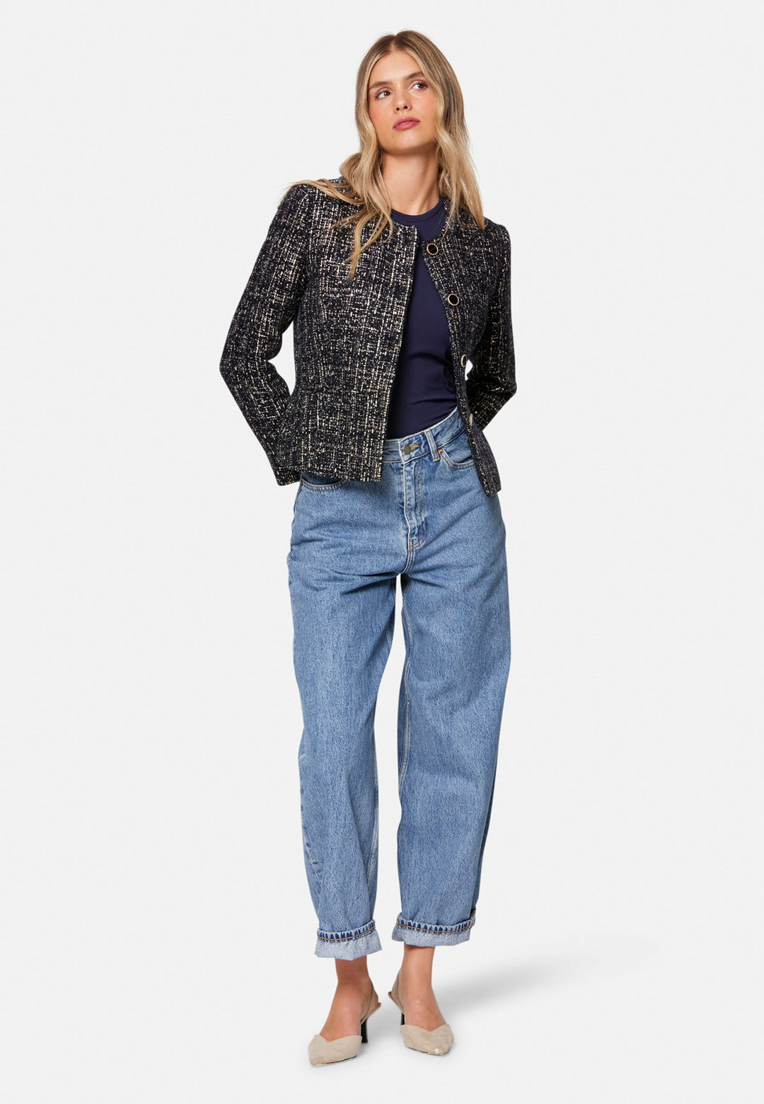 Cassandra, the navy bouclé jacket that pulls everything together. Cut to a neat, waist-defining silhouette with a clean round neckline and long sleeves, it’s woven in textured navy bouclé flecked with light neutrals and burnished metallic threads. Statement gold-rim buttons add polish, while the hip-skimming length makes it effortless over dresses, denim or tailoring. Style with the Lyra or Georgina trousers for a modern suit, or throw on with a tee for off-duty chic.