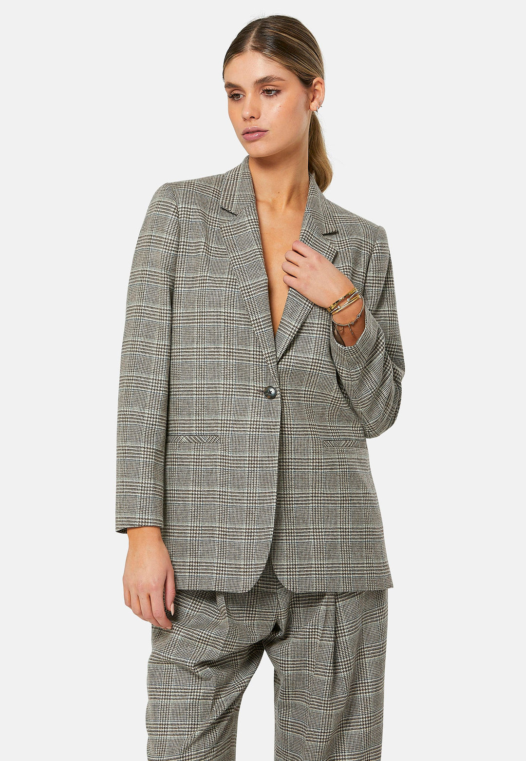 The Cassie Glen Check Jacket, a contemporary silhouette crafted in a soft-touch Magee lamsbwool. This boyfriend blazer boasts a minimalist design with a single button fastening and an oversized, slightly boxy silhouette. Pair the Marlena sleeveless cashmere top and matching Lyra Trousers, an effortless outfit.