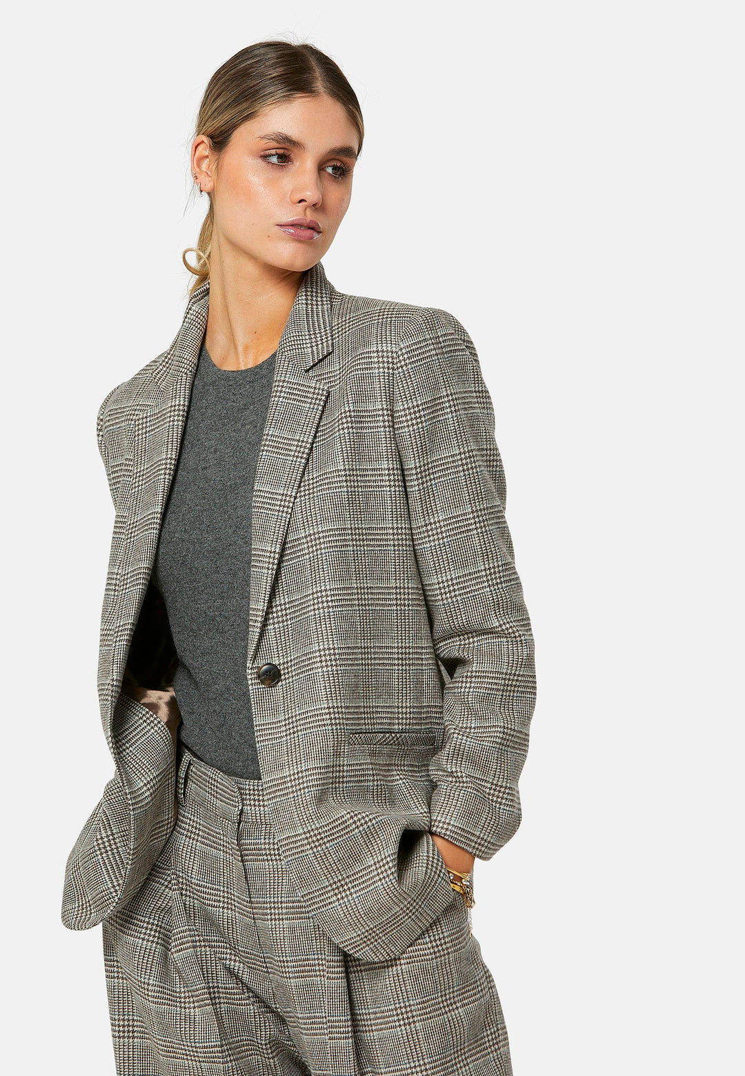 The Cassie Glen Check Jacket, a contemporary silhouette crafted in a soft-touch Magee lamsbwool. This boyfriend blazer boasts a minimalist design with a single button fastening and an oversized, slightly boxy silhouette. Pair the Marlena sleeveless cashmere top and matching Lyra Trousers, an effortless outfit.