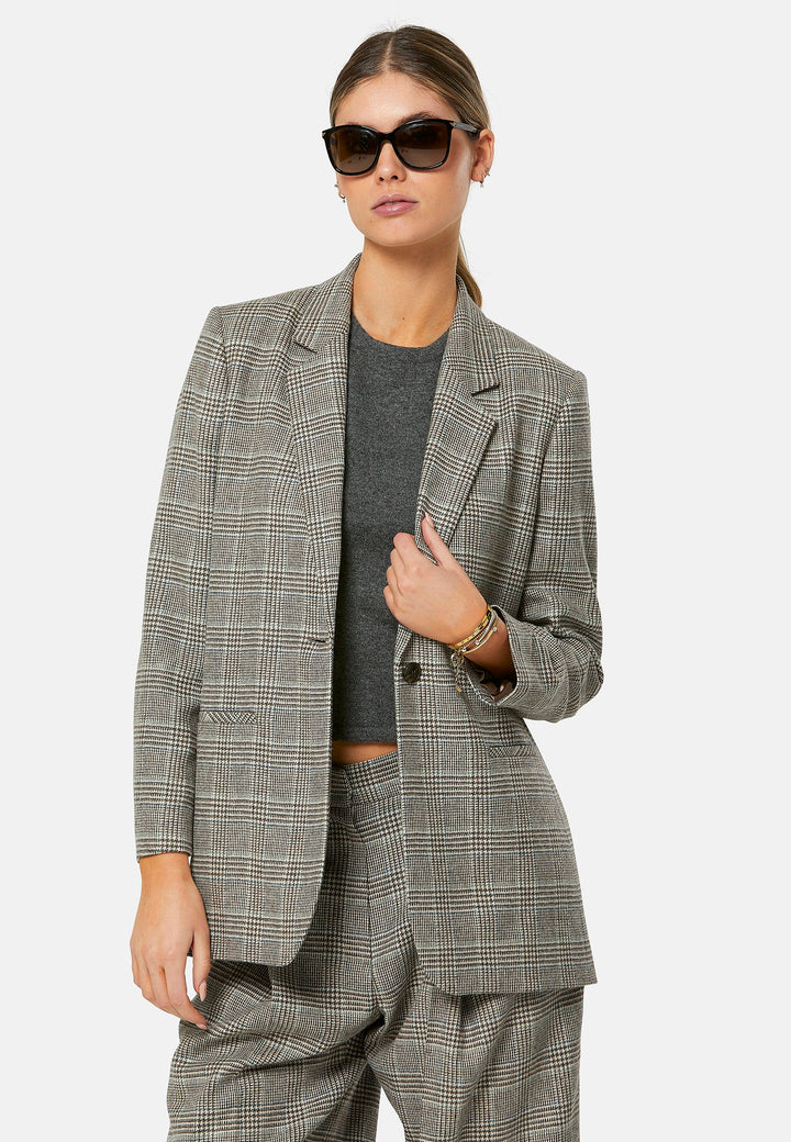 The Cassie Glen Check Jacket, a contemporary silhouette crafted in a soft-touch Magee lamsbwool. This boyfriend blazer boasts a minimalist design with a single button fastening and an oversized, slightly boxy silhouette. Pair the Marlena sleeveless cashmere top and matching Lyra Trousers, an effortless outfit.