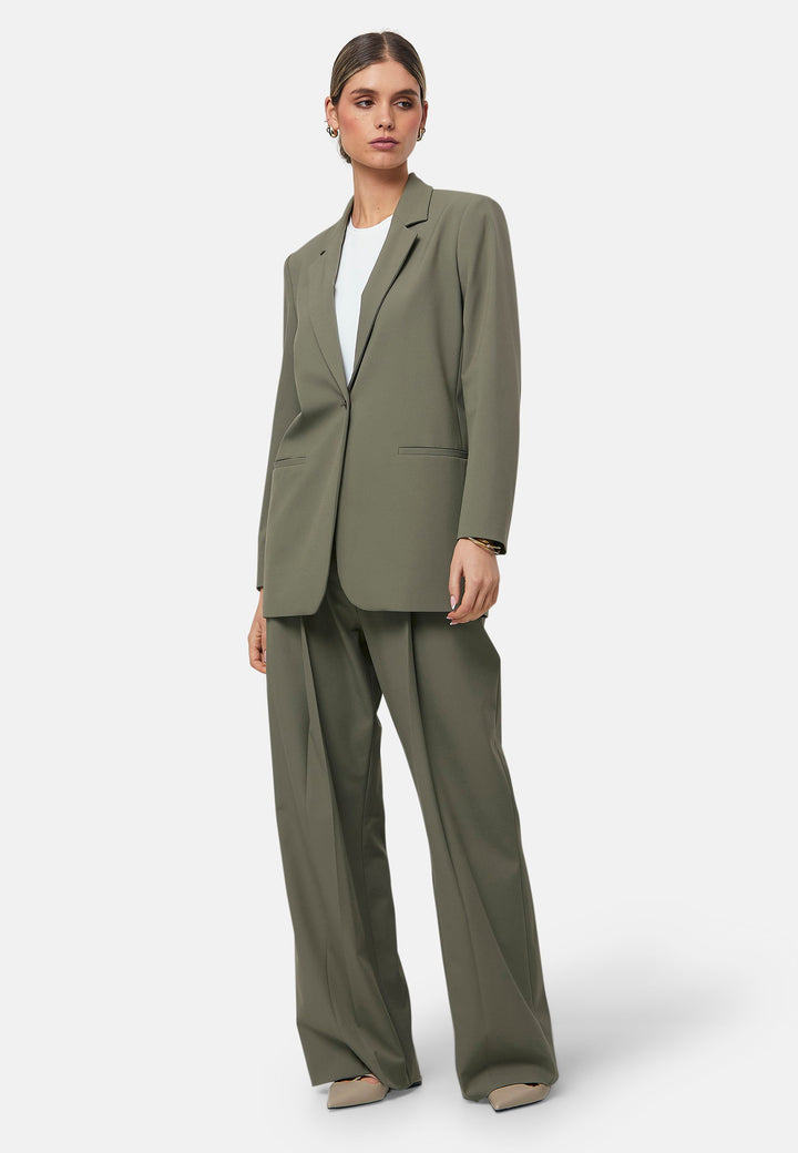 The Cassie Olive boyfriend jacket offers a modern twist on classic tailoring. This sleek, single-button jacket features a relaxed fit, notched lapels, and functional front pockets. Perfect for layering over both casual and formal outfits for a polished look. Pair with the matching Lyra olive trousers to elevate your work wardrobe.