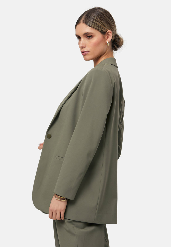 The Cassie Olive boyfriend jacket offers a modern twist on classic tailoring. This sleek, single-button jacket features a relaxed fit, notched lapels, and functional front pockets. Perfect for layering over both casual and formal outfits for a polished look. Pair with the matching Lyra olive trousers to elevate your work wardrobe.