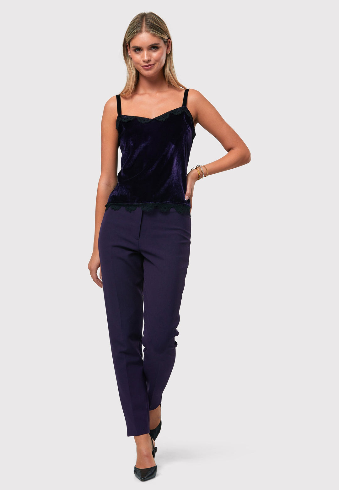 Crafted from a viscose and silk blend with a hint of stretch, the Cleo Velvet Cami in twilight plum features delicate black lace trim on the neckline and hem, complemented by black velvet straps. Pair with the matching velvet suit for a full glam winter look or style with a simple tailored tux for understated elegance.