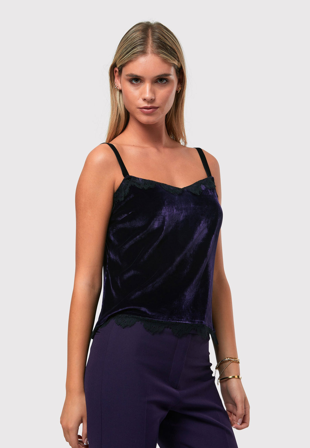 Crafted from a viscose and silk blend with a hint of stretch, the Cleo Velvet Cami in twilight plum features delicate black lace trim on the neckline and hem, complemented by black velvet straps. Pair with the matching velvet suit for a full glam winter look or style with a simple tailored tux for understated elegance.