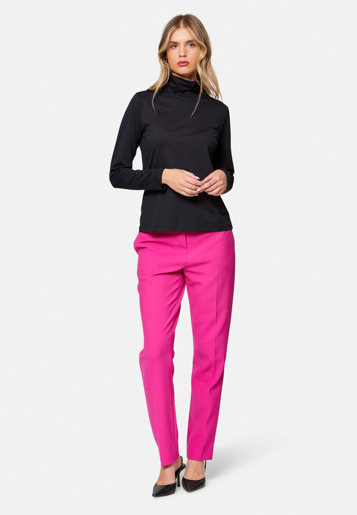 woman wearing high neck and long-sleeved black top with pink trouser