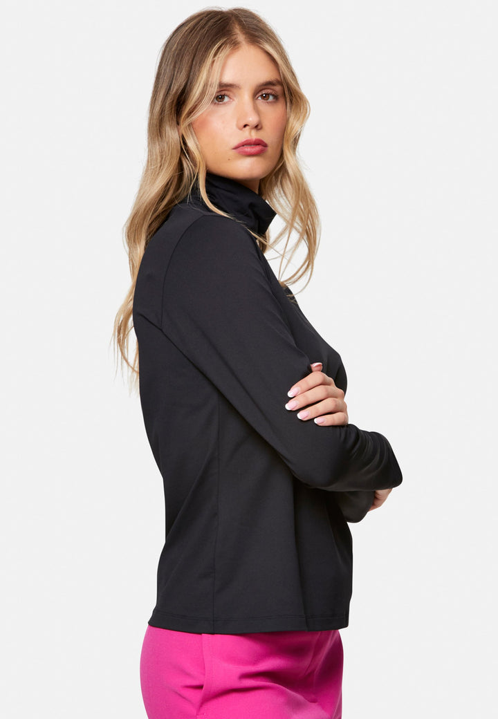 woman wearing high neck and long-sleeved black top with pink trouser