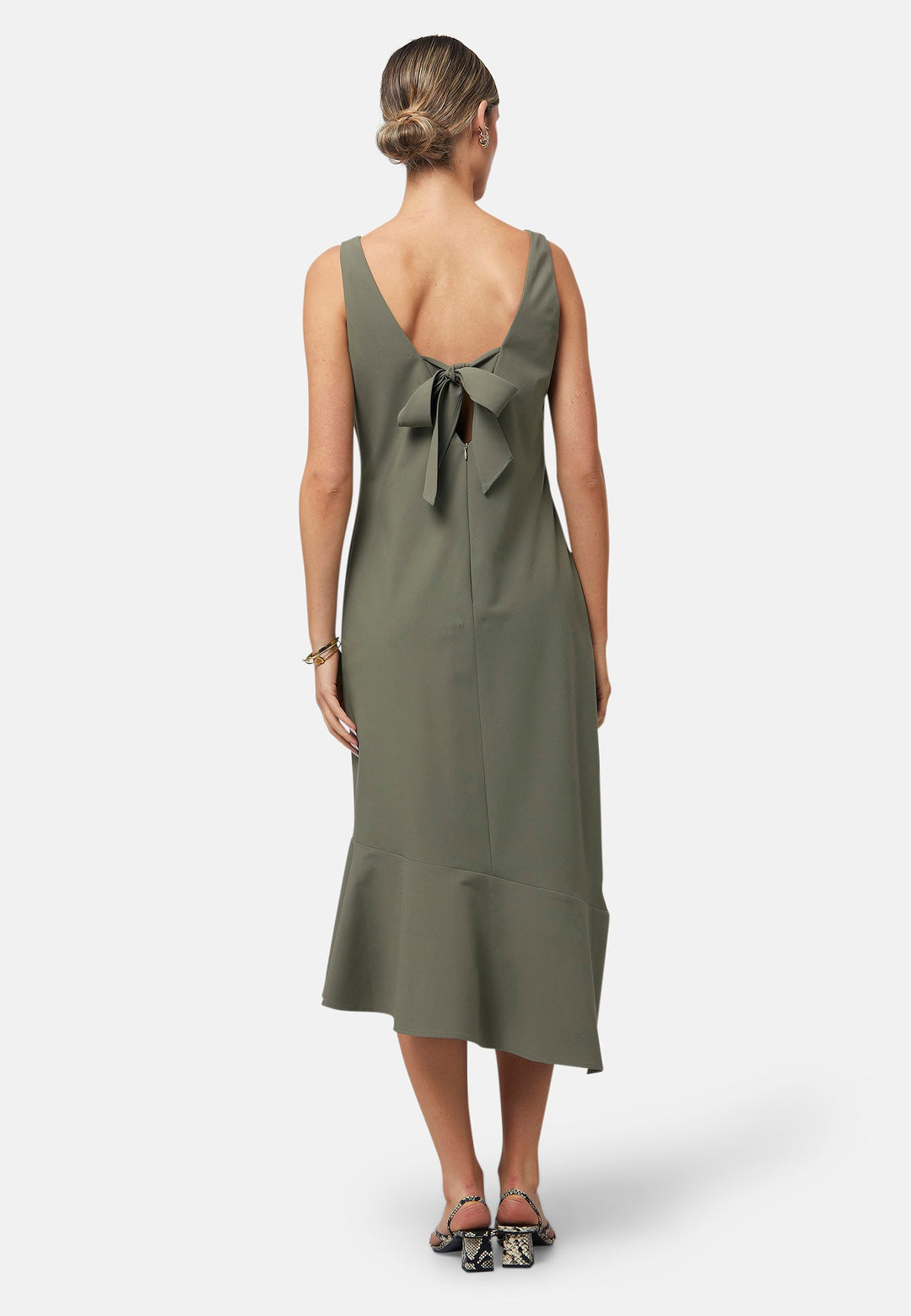 Dylan is a sleeveless midi dress featuring a clean, minimalist silhouette with a V-neckline and a soft, flared hemline for subtle movement. The back showcases an elegant bow detail that adds a touch of visual interest. Made from a smooth, lightweight fabric cut on its bias, the dress ensures comfort and versatility for both casual and formal occasions. Pair it with heels or flats for effortless styling.