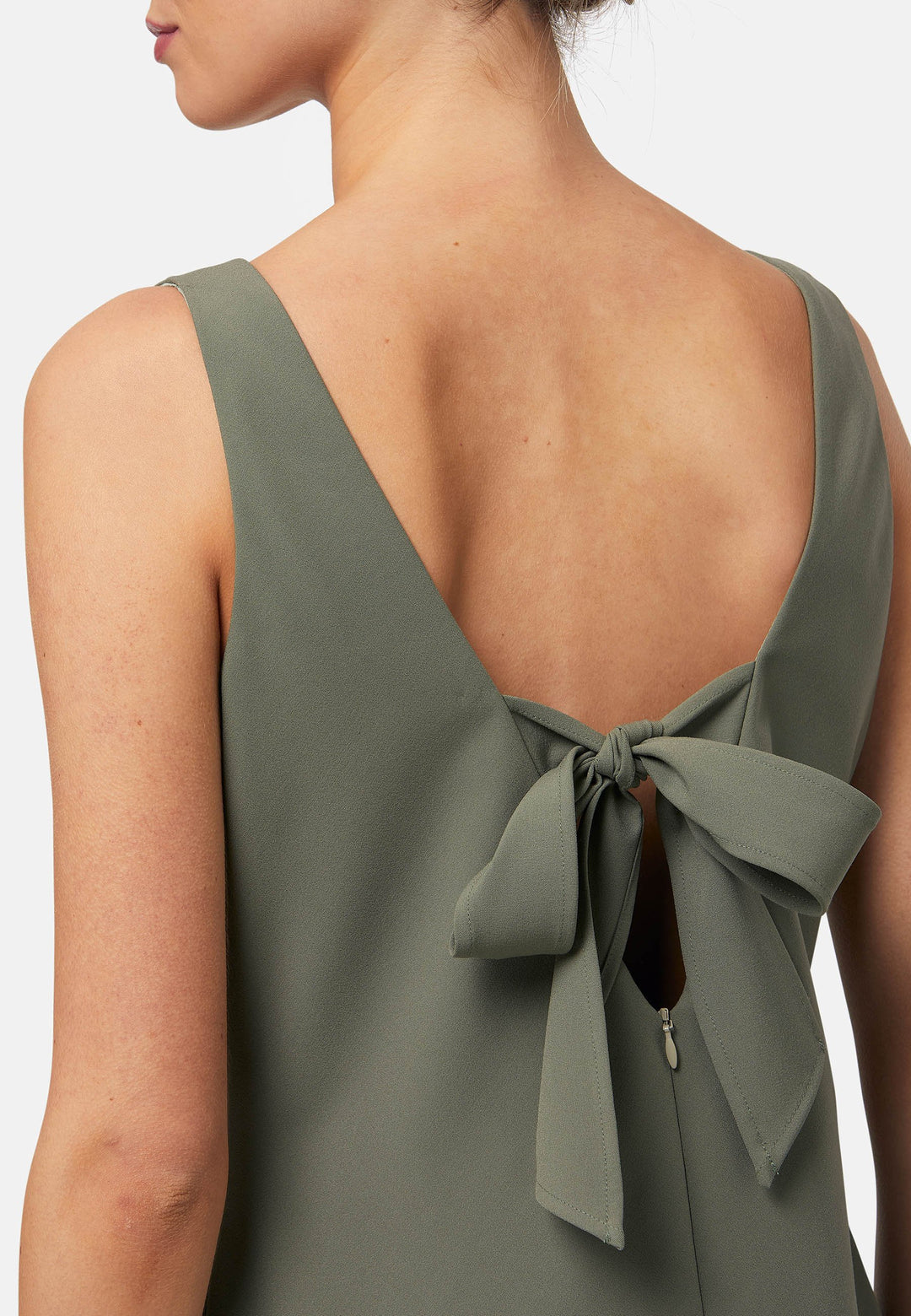 Dylan is a sleeveless midi dress featuring a clean, minimalist silhouette with a V-neckline and a soft, flared hemline for subtle movement. The back showcases an elegant bow detail that adds a touch of visual interest. Made from a smooth, lightweight fabric cut on its bias, the dress ensures comfort and versatility for both casual and formal occasions. Pair it with heels or flats for effortless styling.