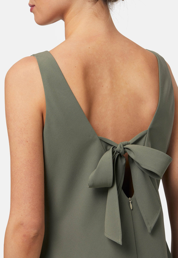 Dylan is a sleeveless midi dress featuring a clean, minimalist silhouette with a V-neckline and a soft, flared hemline for subtle movement. The back showcases an elegant bow detail that adds a touch of visual interest. Made from a smooth, lightweight fabric cut on its bias, the dress ensures comfort and versatility for both casual and formal occasions. Pair it with heels or flats for effortless styling.