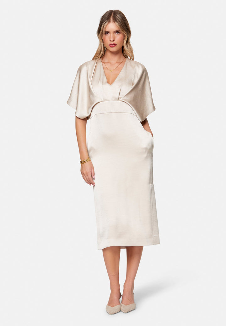 Eabha, the ivory dress with quiet glamour. Cut from fluid, silk-touch satin in a soft oyster hue, it frames the neckline with a gentle V and draped kimono sleeves, then gathers into under-bust pleats that flatter the waistline. The column midi skirt skims beautifully with discreet side seam pockets and slits for ease, finished with a neat keyhole back. Just add barely-there heels and gold jewellery.