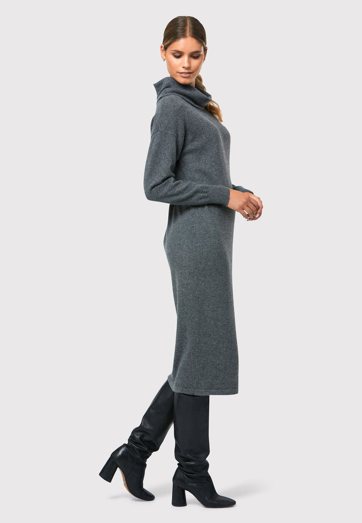 Have you met the Elora Charcoal Grey Cashmere Dress? A chic and versatile addition to your wardrobe. This midi-length dress features a loose, drapey polo neck, exuding effortless elegance. With full-length sleeves and tight ribbed cuffs, it offers a stylish yet comfortable fit. Crafted from luxurious cashmere, this dress effortlessly combines sophistication and comfort, making it the perfect go-to piece for any occasion.
