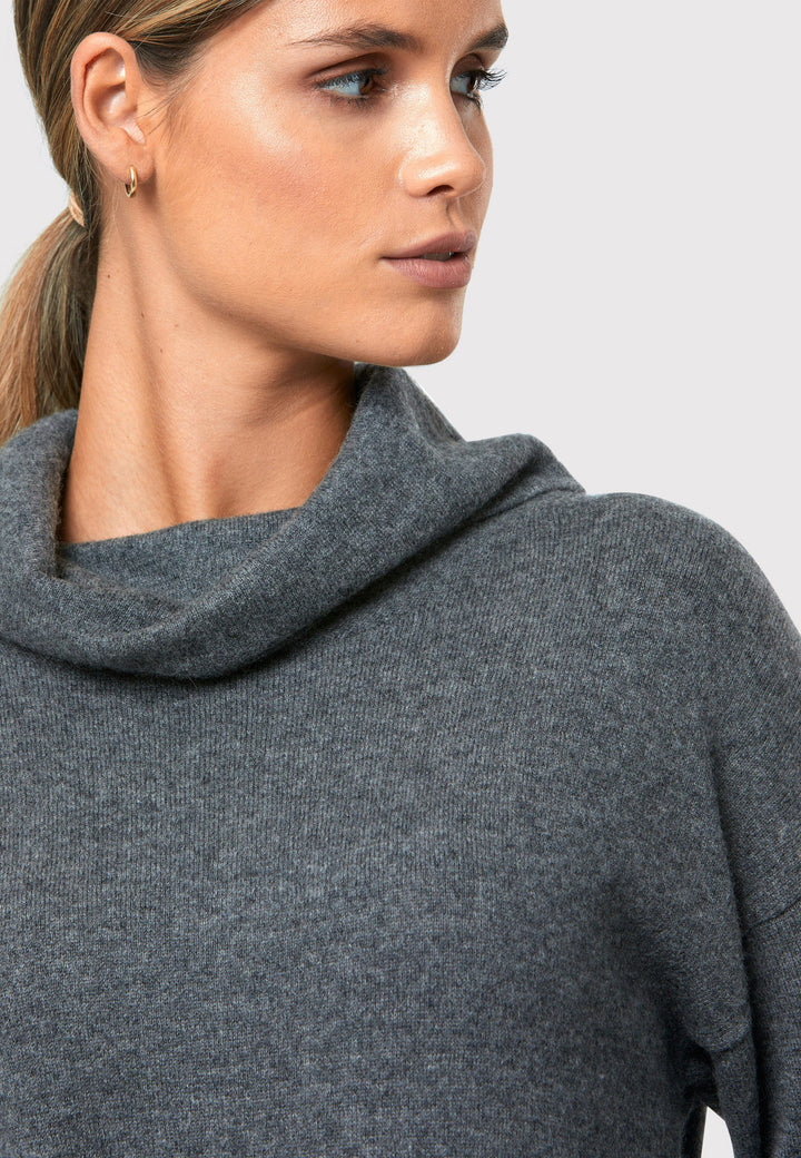 Have you met the Elora Charcoal Grey Cashmere Dress? A chic and versatile addition to your wardrobe. This midi-length dress features a loose, drapey polo neck, exuding effortless elegance. With full-length sleeves and tight ribbed cuffs, it offers a stylish yet comfortable fit. Crafted from luxurious cashmere, this dress effortlessly combines sophistication and comfort, making it the perfect go-to piece for any occasion.