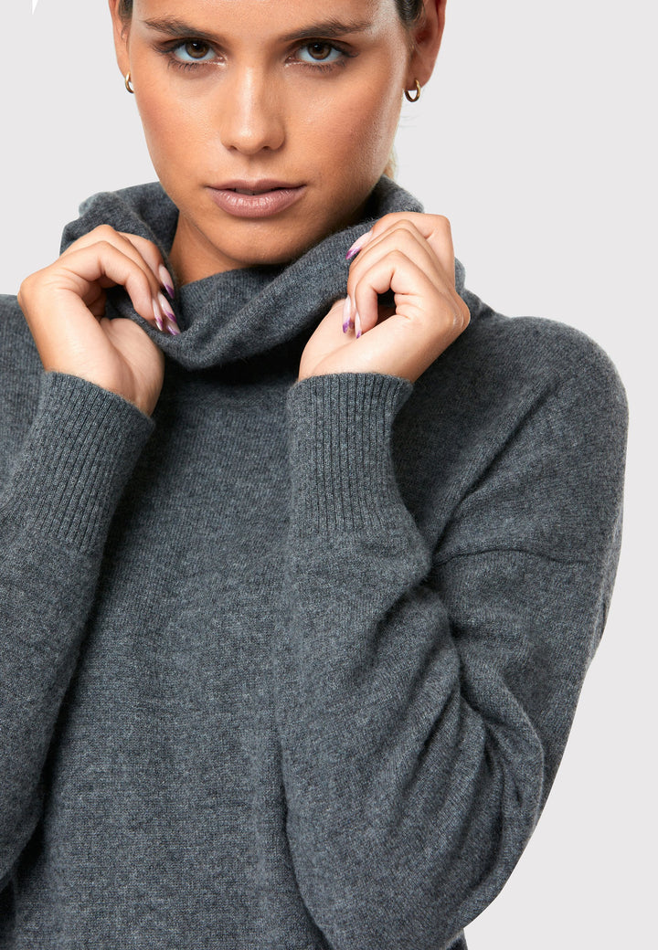 Have you met the Elora Charcoal Grey Cashmere Dress? A chic and versatile addition to your wardrobe. This midi-length dress features a loose, drapey polo neck, exuding effortless elegance. With full-length sleeves and tight ribbed cuffs, it offers a stylish yet comfortable fit. Crafted from luxurious cashmere, this dress effortlessly combines sophistication and comfort, making it the perfect go-to piece for any occasion.
