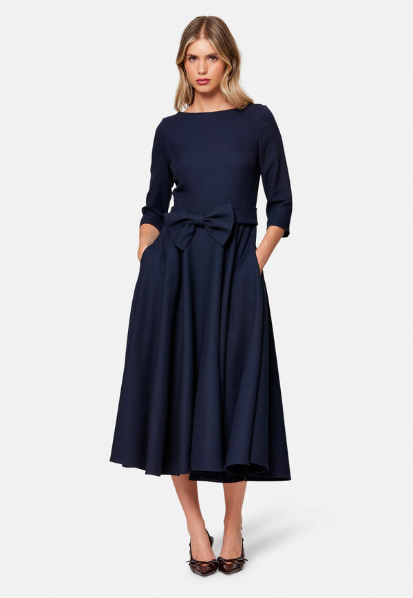 Eva, the modern fit-and-flare. Inspired by Hollywood glamour, this silhouette features a fitted bodice, flared skirt and a flattering scoop back. Designed with a round neckline, side seam pockets and a centre-back zip. The detachable bow belt adds a versatile finishing touch.